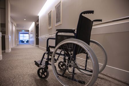 An empty wheelchair in an empty hallway.の写真素材
