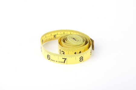 A yellow measuring tape isolated on a white background.の写真素材