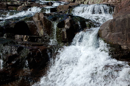 Water cascading over and around large rocks.の写真素材