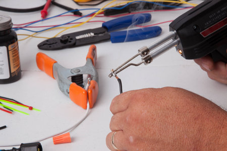 A person soldering wires together.