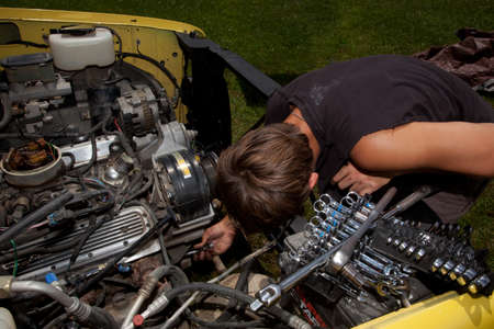 A teenager working on a truck engine.のeditorial素材
