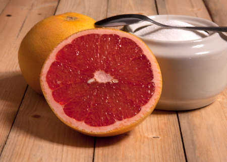 A sliced grapefruit with sugar on a wooden background.の写真素材