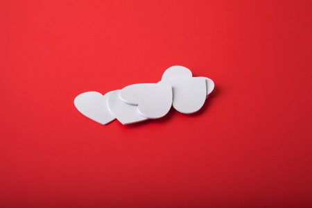 White foam hearts on a red background.