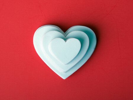 White foam hearts on a red background.の写真素材