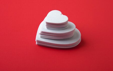 White foam hearts on a red background.の写真素材