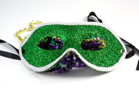 A Mardi Gras mask with beads on a white background.の写真素材