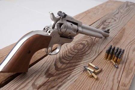 A revolver on a piece of wood.の写真素材