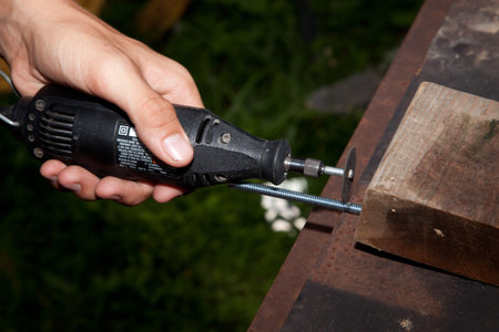 Preparing to cut off a screw with a grinder.