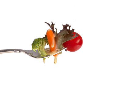 Vegetables on a fork isolated on a white background.の写真素材