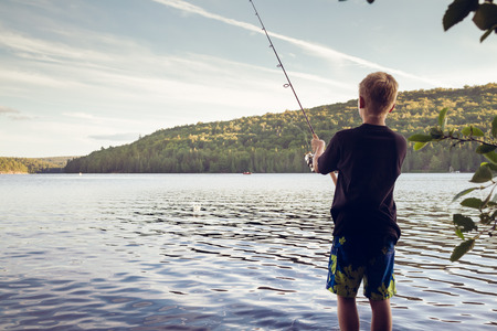 Boy fishing at a lakeの写真素材
