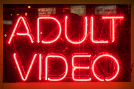 Illuminated neon adult video signの写真素材