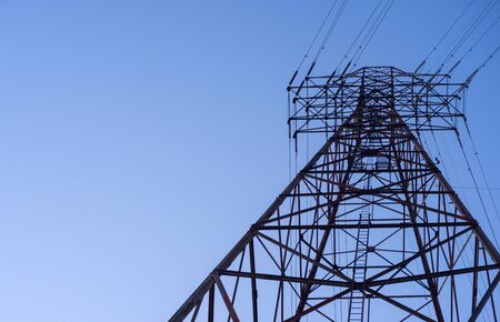 Looking up at an electric transmission towerの写真素材