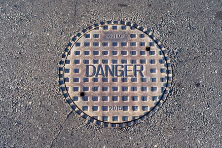 Closed manhole cover on a city streetの写真素材