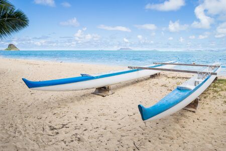 A wooden boat on the shore of a peaceful and quiet Hawaiian beachの写真素材