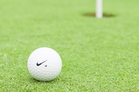 MELBOURNE, AUSTRALIA - JANUARY 18 2014: A Nike golf ball on a green with the hole in the backgroundのeditorial素材