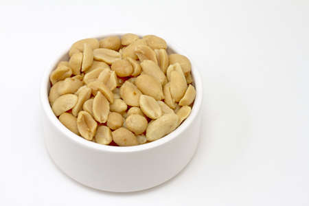 Small white bowl of salted peanutsの写真素材