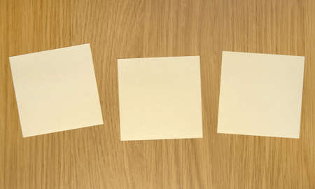 Three yellow sticky notes on wooden doorの写真素材