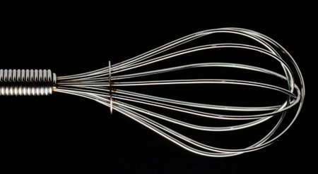 Kitchen balloon whisk on black background