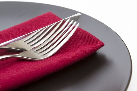 Cutlery on red napkin with plateの写真素材