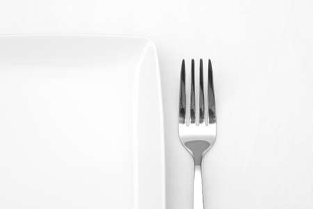 White plate with fork on white table clothの写真素材