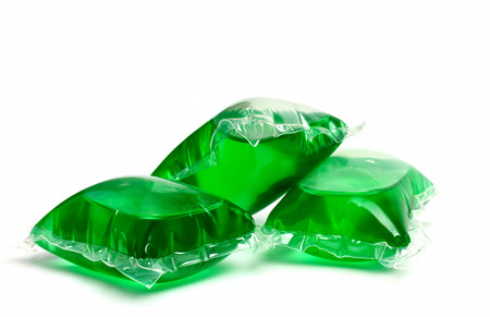 Three green laundry detergent capsules on whiteの写真素材