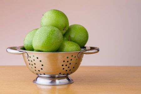 Green apples in a colanderの写真素材