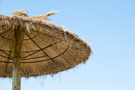 Grass parasol on a blue sky backgroundの写真素材