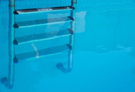 Stainless steel steps under water at a swimming poolの写真素材