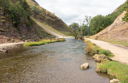 River Dove running through steep hills in Dovedale, Derbyshire UK