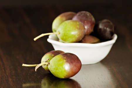 Black/green olives over a wooden tableの写真素材