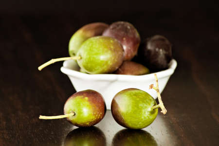 Black/green olives over a wooden tableの写真素材
