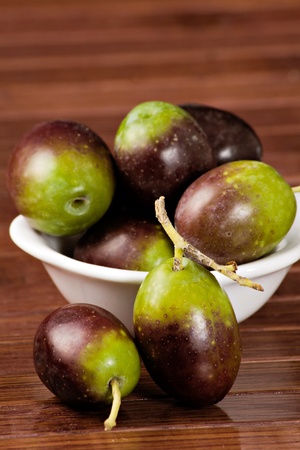 Black/green olives over a wooden tableの写真素材