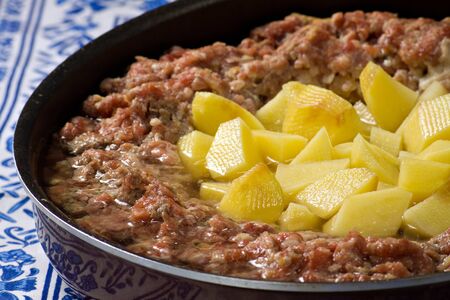 Minced meat pie with potatoes on a white embroidered tablecloth.の写真素材