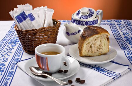 A cup of espesso coffee and a piece of cake for a perfect breakfastの写真素材