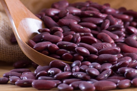 Red beans in a wooden spoon and bagの写真素材