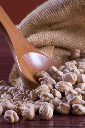 Chickpeas in a wooden spoon and bagの写真素材