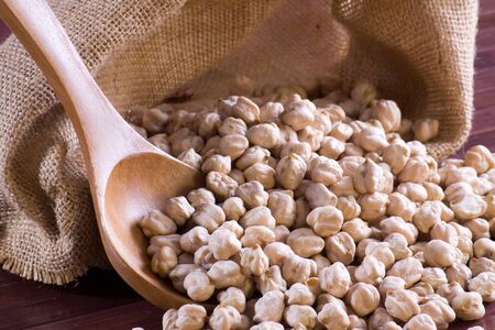 Chickpeas in a wooden spoon and bagの写真素材
