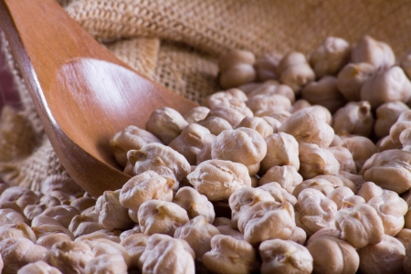 Chickpeas in a wooden spoon and bagの写真素材