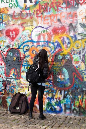 Writer at work, writing on a colorful wall in Prague (Lennon's wall)のeditorial素材