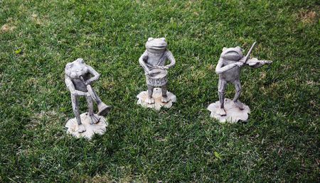 Frog statues appearing to play musical instrumentsの写真素材