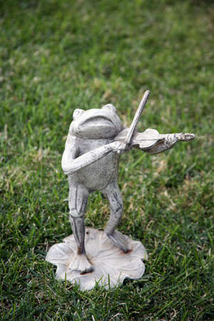 Frog statue playing the violinの写真素材