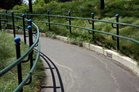 Worn and weathered metal handrail with walkwayの写真素材