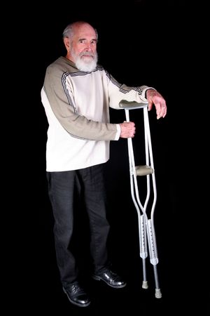 Elderly married, man holding crutches isolated on black backgroundの写真素材