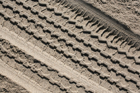 Clear impression of a tire track in beach sand background