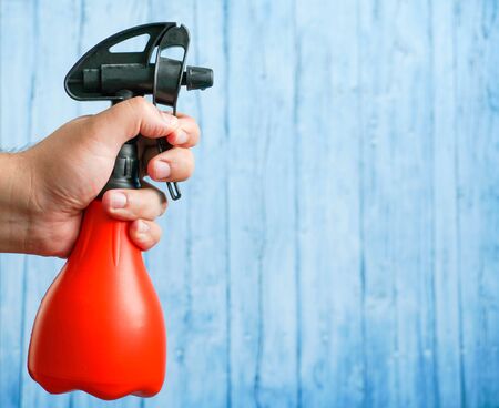 sprayer for plants in a male hand on a blue background.の写真素材