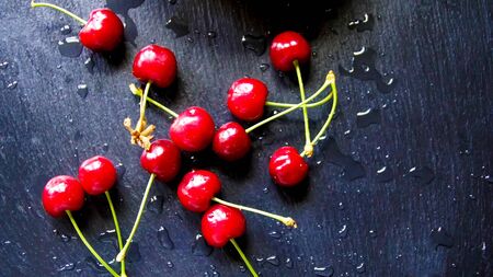 Ripe cherry with stems and leaves. Big collection of red berries. Ripe background. Selective focusの写真素材