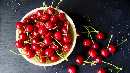 Ripe cherry with stems and leaves. Big collection of red berries. Ripe background. Selective focusの写真素材