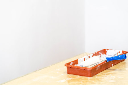 Close-up of paint roller in tray during repair work indoors.の写真素材