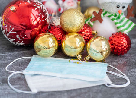Horizontal color image with a view of Christmas decoration with coronavirus in the background, Christmas socks, face masks and toys. Covid concept for christmasの写真素材