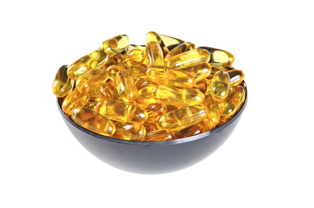 Bowl with Omega 3 (fish oil) pills, isolated on white backgroundの写真素材
